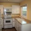 The updated white kitchen looks out over a large privacy-fenced offer House For Rent